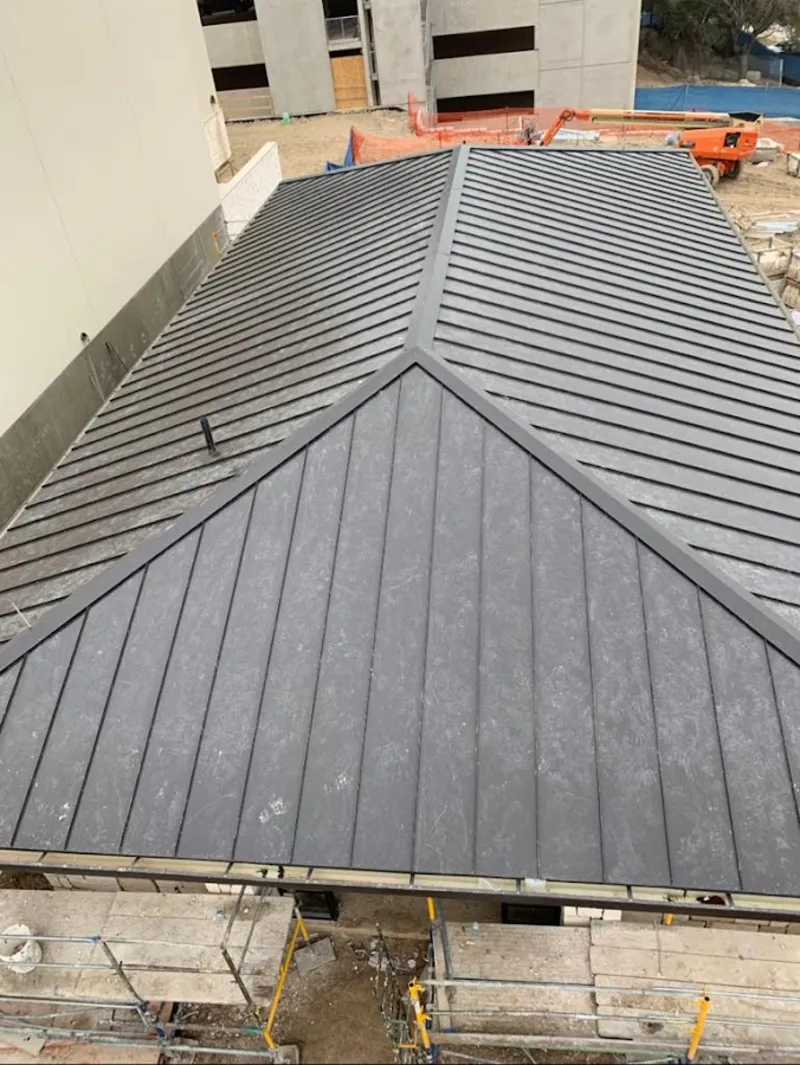 Commercial metal roof construction with crane equipment in Paris